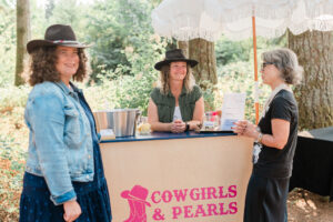 Three women standing at a mobile bar during a fundraising event.
